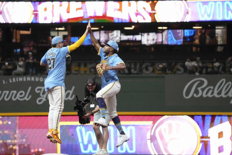 El dominicano Willy Adames, de los Cerveceros de Milwaukee, festeja con el venezolano Jackson Chourio, tras el triunfo sobre los Guardianes de Cleveland, el viernes 16 de agosto de 2024 (AP Foto/Kayla Wolf)
