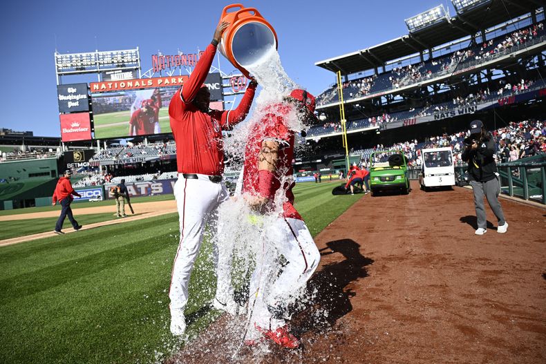 Josh Bell de los Nacionales de Washington lanza agua a su compañero Luis García Jr. tras la victoria ante los Mets de Nueva York el domingo 27 de abril del 2025. (AP Foto/Nick Wass)