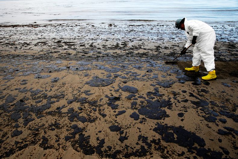 ARCHIVO - Un trabajador retira petróleo en la playa estatal Refugio, el 21 de mayo de 2015, al norte de Goleta, California. (AP Foto/Jae C. Hong, archivo)