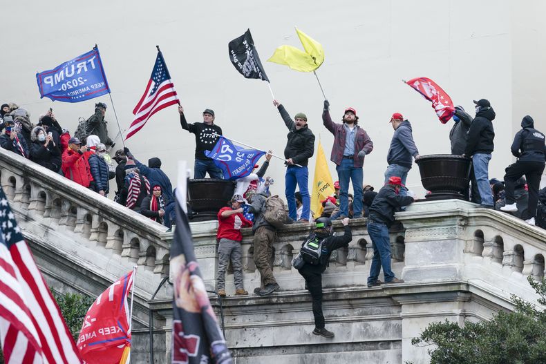 ARCHIVO - Manifestantes agitan banderas en el frente oeste del Capitolio de Estados Unidos en Washington el 6 de enero de 2021. (AP foto/Jose Luis Magana, archivo)