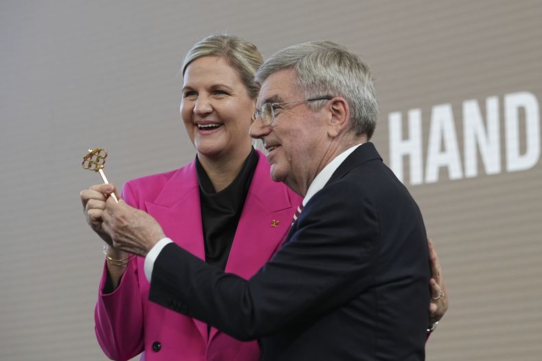 El presidente del COI Thomas Bach y la presidenta electa Kristy Coventry posa con la llave simbólica de la presidencia en una ceremonia de sucesión en la Casa Olímpica en Lausana, Suiza el luens 23 de junio del 2025. (AP Foto/Laurent Cipriani)