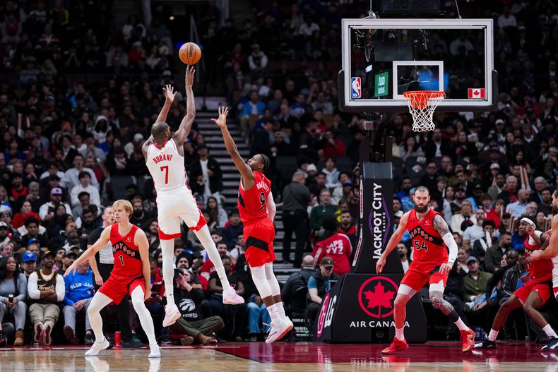 Kevin Durant, alero de los Rockets de Houston, dispara frente a RJ Barrett, de los Raptors de Toronto, durante el duelo del miércoles 29 de octubre de 2025 (Thomas Skrlj/The Canadian Press via AP)