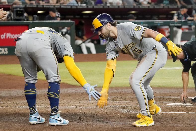 Garrett Mitchell, de los Cerveceros de Milwaukee, a la derecha, le da una palmada a William Contreras, a la izquierda, después de conectar un jonrón de dos carreras contra los Diamondbacks de Arizona durante la cuarta entrada el sábado 14 de septiembre de 2024, en Phoenix. (AP Foto/Darryl Webb)