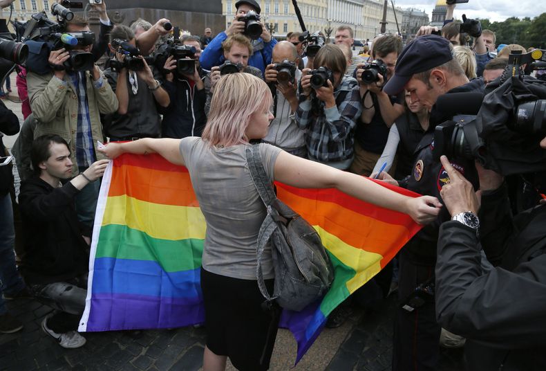 Una activista por los derechos de los homosexuales de pie con una bandera del arcoíris, frente a los periodistas, durante una protesta en la plaza Dvortsovaya, en San Petersburgo, Rusia, el 2 de agosto de 2015. (Foto AP, Archivo)