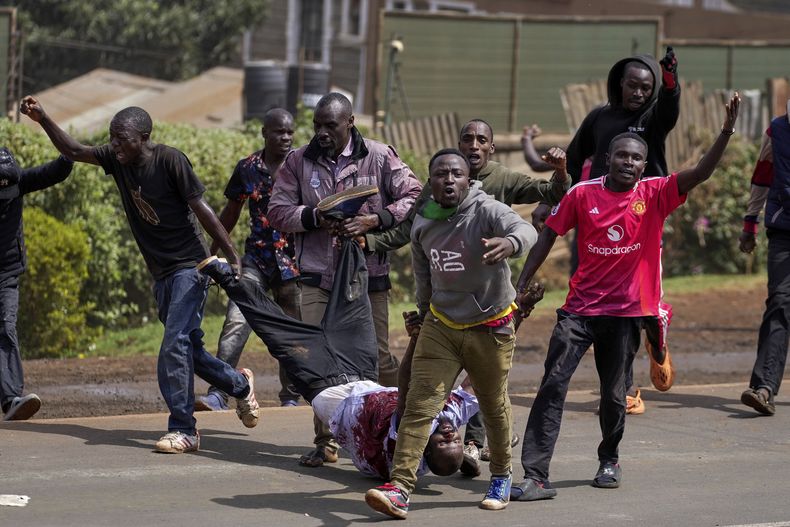 Manifestantes se llevan a un hombre al parecer herido a bala por la policía durante protestas en el barrio pobre de Kangemi en Nairobi, Kenia, el 7 de julio del 2025. (AP foto/Brian Inganga)
