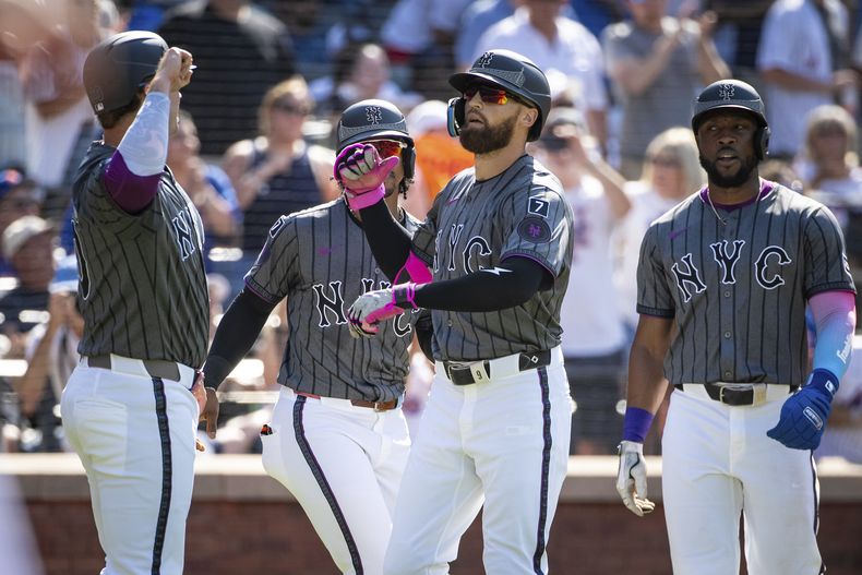 Brandon Nimmo, de los Mets de Nueva York, celebra su grand slam con los anotadores, Pete Alonso, Francisco Lindor y Starling Marte, durante la primera entrada de un partido de béisbol contra los Yankees de Nueva York, el sábado 5 de julio de 2025, en Nueva York. (AP Photo/Angelina Katsanis)