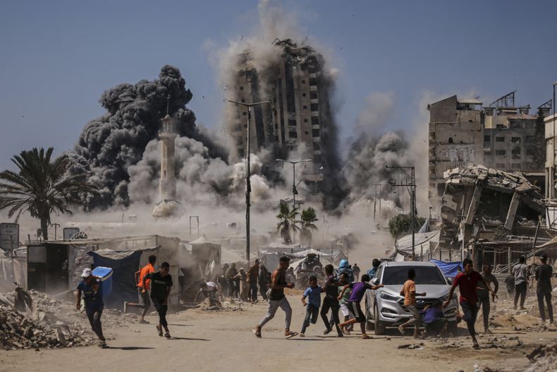 Palestinos corren para protegerse durante un ataque aéreo israelí contra un edificio de gran altura en la Ciudad de Gaza, el viernes 5 de septiembre de 2025, después de que Israel lanzara una advertencia previa. (AP Foto/Yousef Al Zanoun)