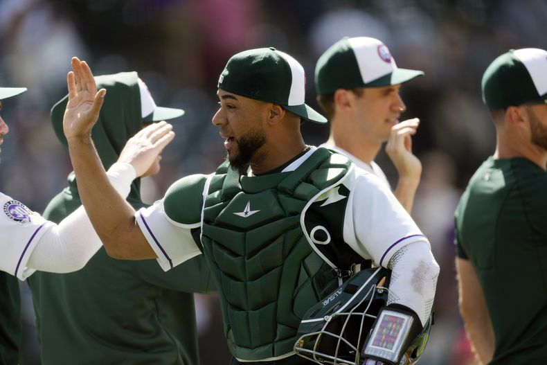 El venezolano Elías Díaz, de los Rockies de Colorado, festeja con sus compañeros tras la victoria sobre los Rojos de Cincinnati, el miércoles 17 de mayo de 2023 (AP Foto/David Zalubowski)