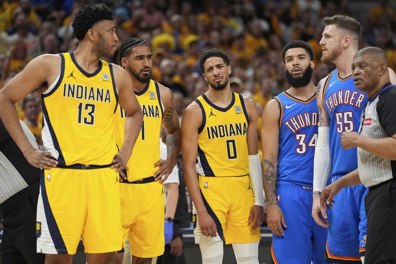 Tony Bradley (13), pívot de los Pacers de Indiana, mira a Isaiah Hartenstein (55), pívot del Thunder de Oklahoma City, tras una falta mientras el base Tyrese Haliburton (0) mira a Bradley durante la segunda mitad del Juego 6 de la serie de baloncesto de las Finales de la NBA, el jueves 19 de junio de 2025, en Indianápolis. (AP Foto/Abbie Parr)