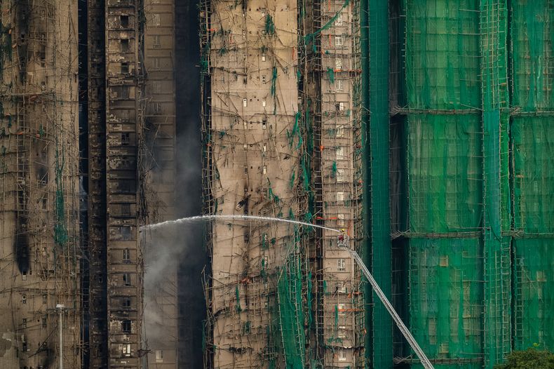 Bomberos trabajan para extinguir un incendio que comenzó el miércoles en Wang Fuk Court, un complejo residencial en el distrito de Tai Po en los Nuevos Territorios de Hong Kong, el jueves 27 de noviembre de 2025. (AP Foto/Chan Long Hei)