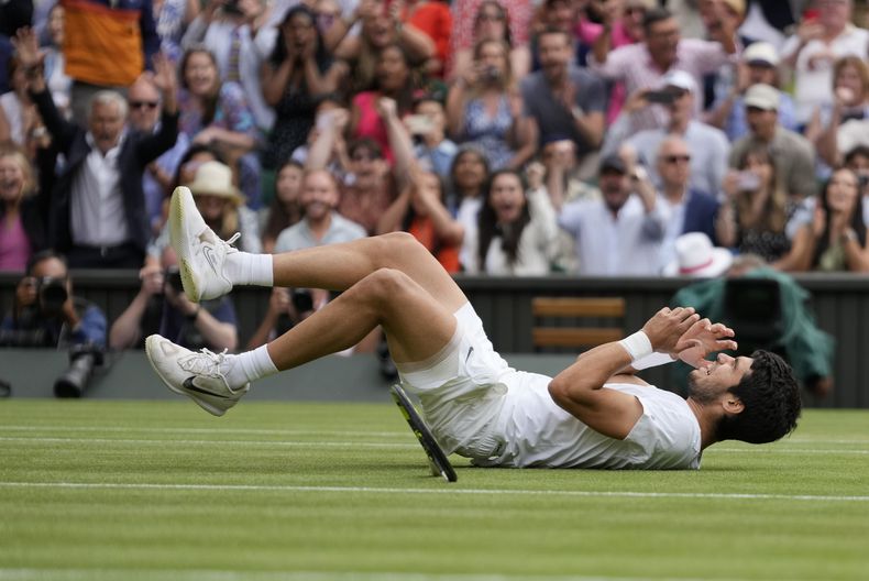 Carlos Alcaraz se recuesta tras derrotar a Novak Djokovic en la final de Wimbledon, el domingo 16 de julio de 2023, en Londres. (AP Foto/Kirsty Wigglesworth)