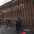 Oficiales federales estadounidenses le quitan las esposas a hombres antes de liberarlos cerca de la muralla fronteriza en San Diego el 15 de marzo de 2023. (Foto AP /Gregory Bull)