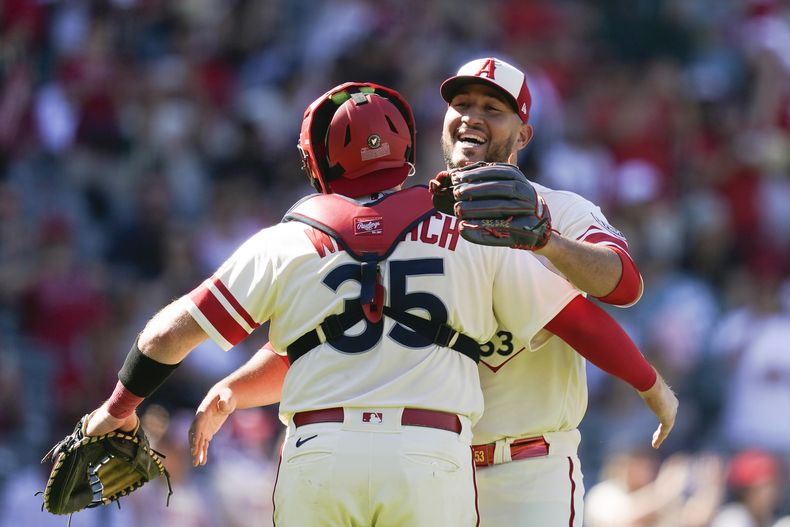El relevista dominicano de los Angelinos de Los Ángeles Carlos Estévez abraza al receptor Chad Wallach (35) luego de la victoria del equipo sobre los Guardianes de Cleveland, en Anaheim, California. Domingo 10 de septiembre de 2023. (AP Foto/Ryan Sun)