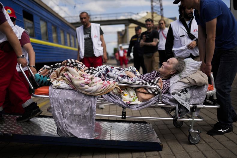 Un paciente mayor es subido a un tren médico de desalojo operado por Médicos Sin Fronteras en la estación de tren en Pokrovsk, este de Ucrania, el domingo 29 de mayo de 2022. (AP Foto/Francisco Seco)