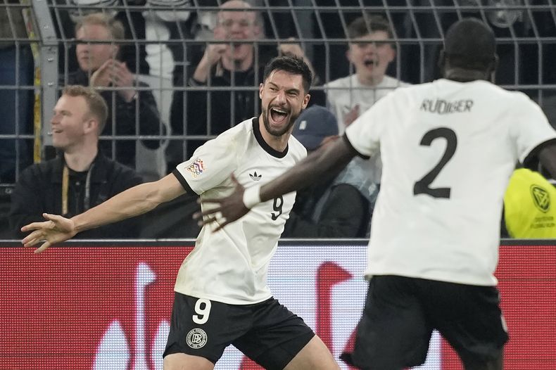 Tim Kleindienst, izquierda, de Alemania, celebra después de marcar el tercer gol de su equipo con Antonio Rudiger durante el partido de fútbol de cuartos de final de la Liga de Naciones entre Alemania e Italia, en el Signal-Iduna Park en Dortmund, Alemania, el domingo 23 de marzo de 2025. (AP Foto/Martin Meissner)