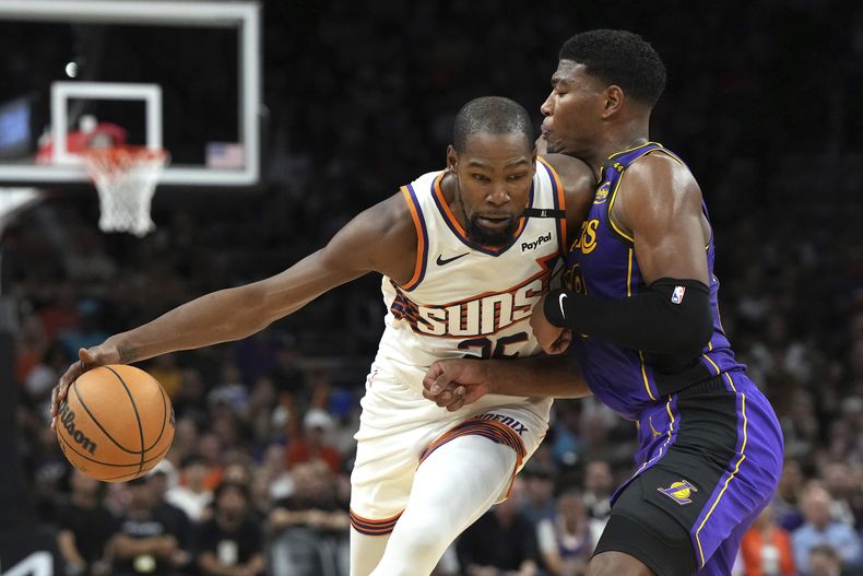 El jugador de los Suns de Phoenix Kevin Durant (35) trata de avanzar contra el jugador de los Lakers de Los Ángeles Rui Hachimura, a la derecha, en la primera mitad de su juego de NBA el lunes 28 de octubre de 2024 en Phoenix. (AP Foto/Rick Scuteri)