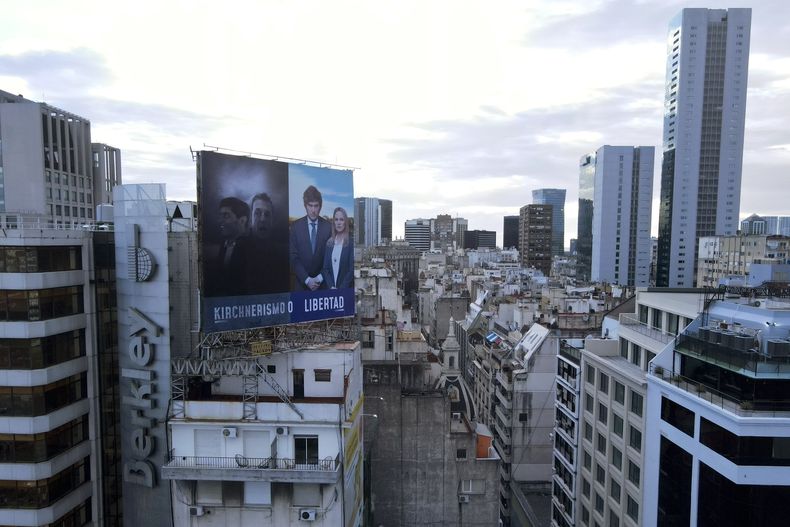 Un cartel de campaña del candidato presidencial Javier Milei y Carolina PÍparo, que se postula para la gobernación de la provincia de Buenos Aires, se yuxtapone con fotografías del actual ministro de Economía, Sergio Massa, también candidato a la presidencia, y del actual gobernador de la provincia de Buenos Aires Axel Kicillof, quien se postula para la reelección, en Buenos Aires, Argentina, el jueves 19 de octubre de 2023. (AP Foto/Natacha Pisarenko)