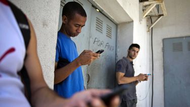 americateve | Estudiantes reunidos detr&aacute;s de un negocio intentan encontrar una se&ntilde;al de internet para sus tel&eacute;fonos multifuncionales en La Habana, Cuba, el 1 de abril de 2014. El gobierno de Costa Rica dice que aguarda una explicaci&oacute;n de Est
