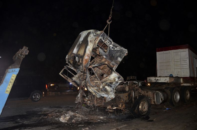 Rescatistas quitan un tráiler que chocó contra vehículos detenidos y se incendió en una carretera de Abuya, Nigeria, el miércoles 19 de marzo de 2025. (AP Foto/Olamikan Gbemiga)