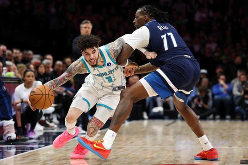 LaMelo Ball (1), de los Hornets de Charlotte, pasa a Naz Reid (11), de los Timberwolves de Minnesota, durante la segunda mitad del juego de baloncesto de la NBA, el domingo 5 de abril de 2026, en Minneapolis. (AP Foto/Matt Krohn)