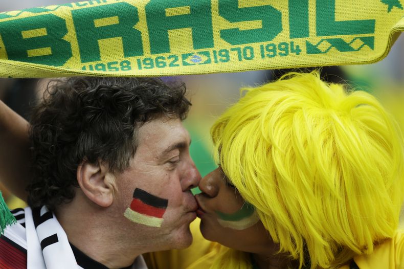 Un hincha alem&aacute;n y una seguidora de Brasil se besan antes de la semifinal de la Copa del Mundo entre ambos pa&iacute;ses, el martes 8 de julio de 2014, en Belo Horizonte (AP Foto/Natacha Pisarenko)