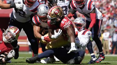 El linebacker de los Patriots de Nueva Inglaterra, Joshua Uche, abajo en el centro a la derecha, y sus compañeros de equipo taclean al corredor de los 49ers de San Francisco, Jordan Mason (24), durante la primera mitad de un partido en Santa Clara, California, el domingo 29 de septiembre de 2024. (AP Foto/Godofredo A. Vásquez)
