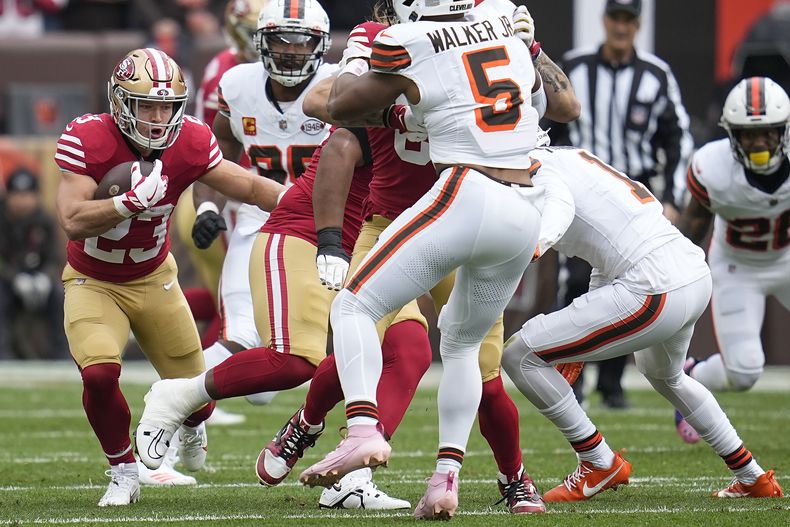 Christian McCaffrey (23), corredor de los 49ers de San Francisco, busca un carril para explotar frente a la defensiva de los Browns de Cleveland, durante la primera mitad del juego de la NFL, el domingo 15 de octubre de 2023, en Cleveland. (AP Foto/Sue Ogrocki)