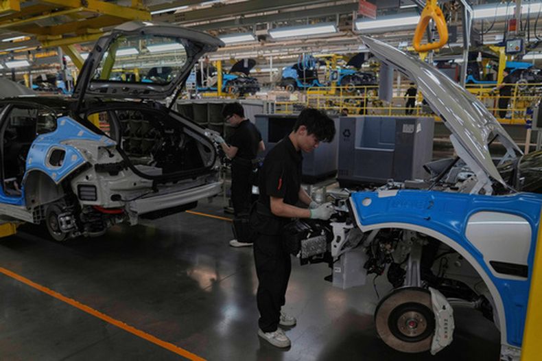ARCHIVO - Trabajadores ensamblan los modelos Zeekr 001 EV en la planta de montaje del fabricante chino Zeekr en Ningbo, provincia de Zhejiang, al este de China, el 17 de abril de 2025. (Foto AP/Andy Wong, Archivo)