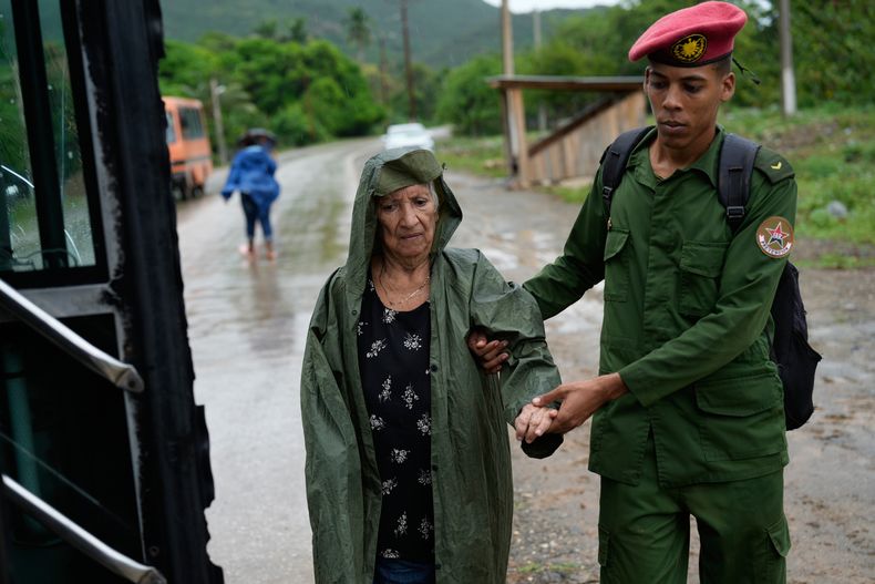 Un soldado ayuda a una mujer a evacuar antes de la llegada del huracán Melissa en Canizo, una comunidad de Santiago de Cuba, el martes 28 de octubre de 2025. (Foto AP/Ramón Espinosa)