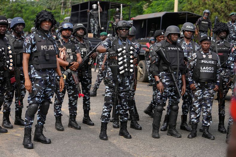 Policías nigerianos hacen guardia durante una procesión a la luz de velas en honor a los manifestantes muertos en una protesta por las dificultades económicas, en Lagos, Nigeria, viernes 9 de agosto de 2024. (AP Foto/Sunday Alamba, Archivo)