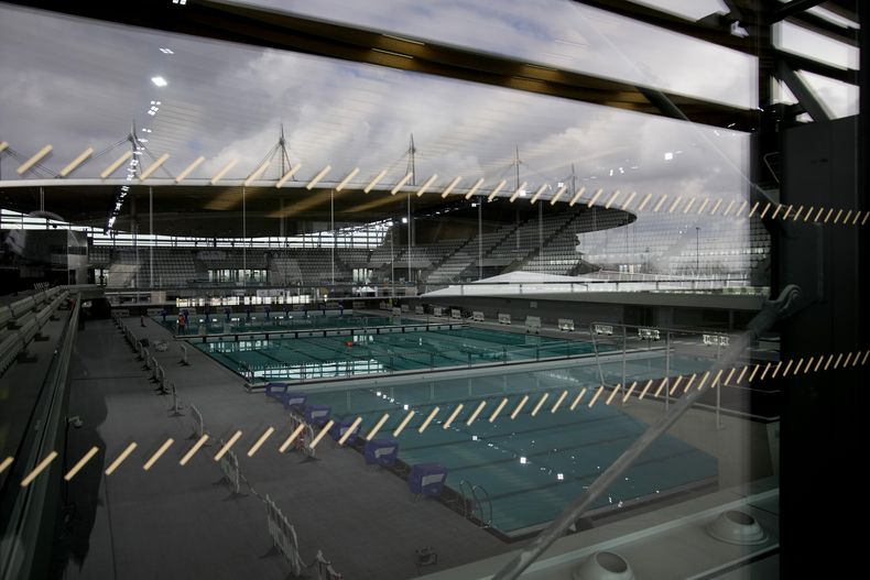 El Stade de France se refleja en la ventana del Centro Acuático de los Juegos Olímpicos de París, el martes 6 de marzo de 2024, en Saint-Denis. (AP Foto/Christophe Ena)