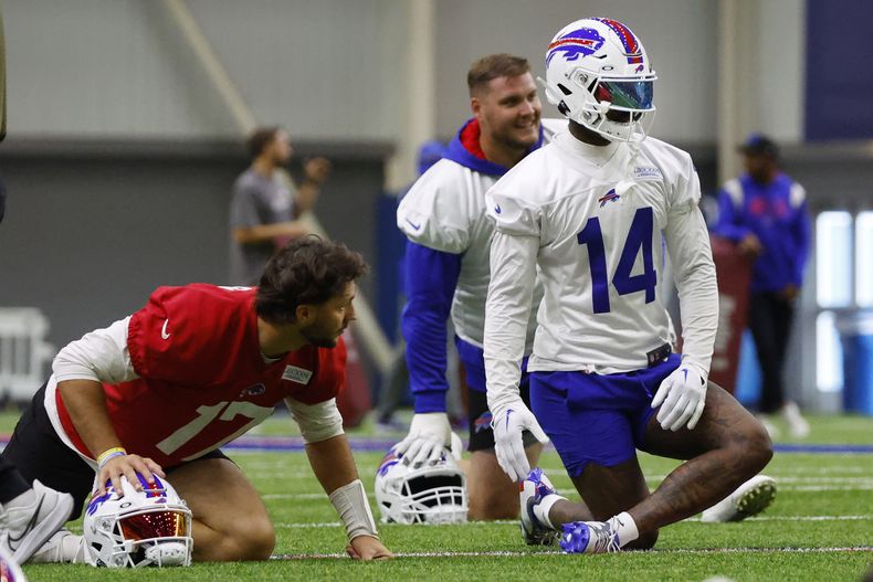 Josh Allen (17), quarterback de los Bills de Buffalo, y el wide receiver Stefon Diggs (14) estiran durante el entrenamiento del equipo en Orchard Park, Nueva York, el miércoles 14 de junio de 2023. (AP Foto/Jeffrey T. Barnes)