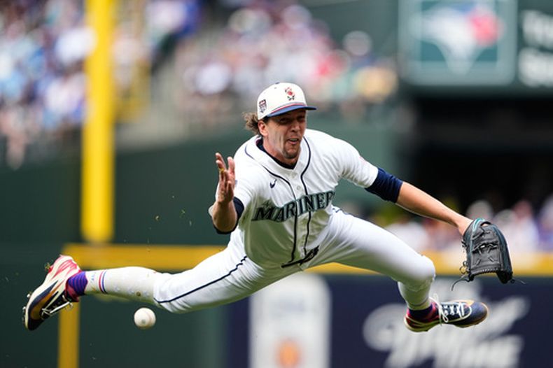 Logan Gilbert, abridor de los Marineros de Seattle, hace un lanzamiento de asistencia para retirar en primera base a Nathan Lukes, de los Azulejos de Toronro, durante la cuarta entrada del juego de béisbol de Grandes Ligas, el sábado 4 de julio de 2026, en Seattle. (AP Foto/Lindsey Wasson)