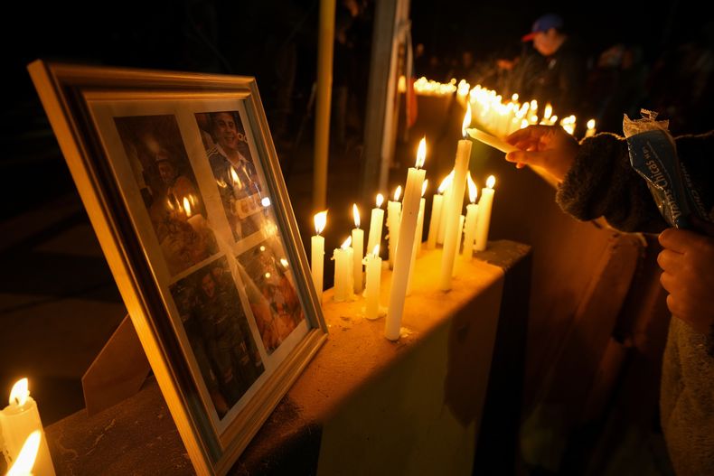 Una persona enciende una vela durante una vigilia frente a la mina de cobre El Teniente, operada por Codelco, donde ocurrió un derrumbe y varias personas fallecieron, el sábado 2 de agosto de 2025, en Rancagua, Chile. (AP Foto/Esteban Félix)