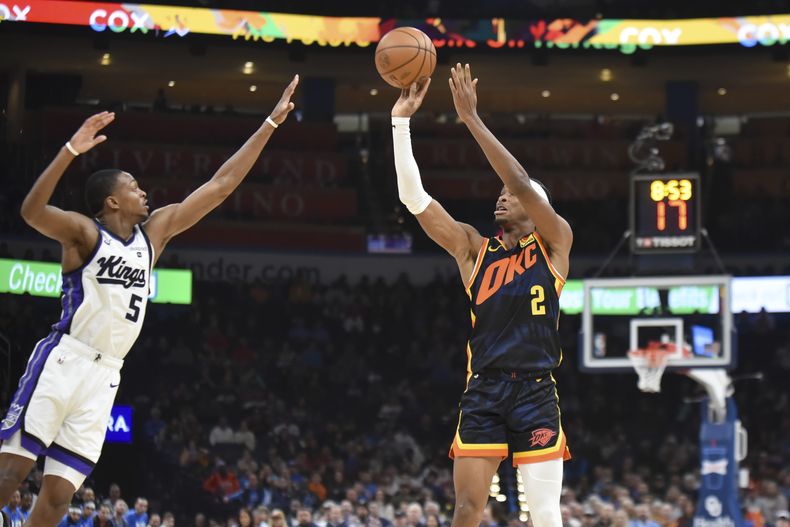 Shai Gilgeous-Alexander (2) del Thunder de Oklahoma City dispara al aro ante DeAaron Fox (5) de los Kings de Sacramento, el 11 de febrero de 2024, en Oklahoma City. (AP Foto/Kyle Phillips)