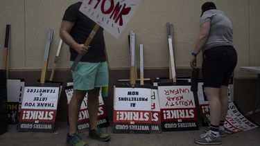 Dos manifestantes toman carteles en un mitin en el exterior de los estudios de Paramount Pictures en Los Ángeles, el 21 de septiembre de 2023. (AP Foto/Jae C. Hong)