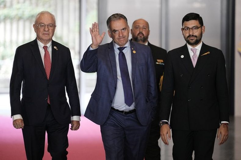 El presidente uruguayo Yamandú Orsi, centro, saluda a los periodistas a su llegada a la cumbre de la Comunidad de Estados Latinoamericanos y Caribeños (CELAC-ÁFRICA) en Bogotá, Colombia, el sábado 21 de marzo de 2026. (Foto AP/Ivan Valencia)