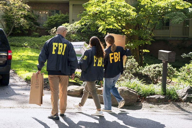 Agentes del FBI llevan cajas vacías a la casa del exasesor de Seguridad Nacional de Estados Unidos, John Bolton, el viernes 22 de agosto de 2025, en Bethesda, Maryland. (AP Foto/Jose Luis Magana)