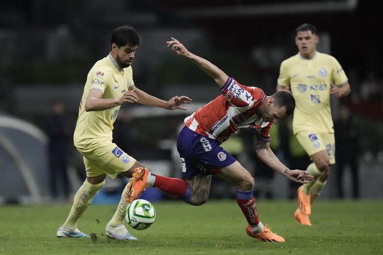 Leo Bonatini, del Atlético de San Luis, trata de avanzar ante Néstor Araujo, del América, en la vuelta de los cuartos de final de la Liga MX, el sábado 13 de mayo de 2023, en el Estadio Azteca (AP Foto/Eduardo Verdugo)