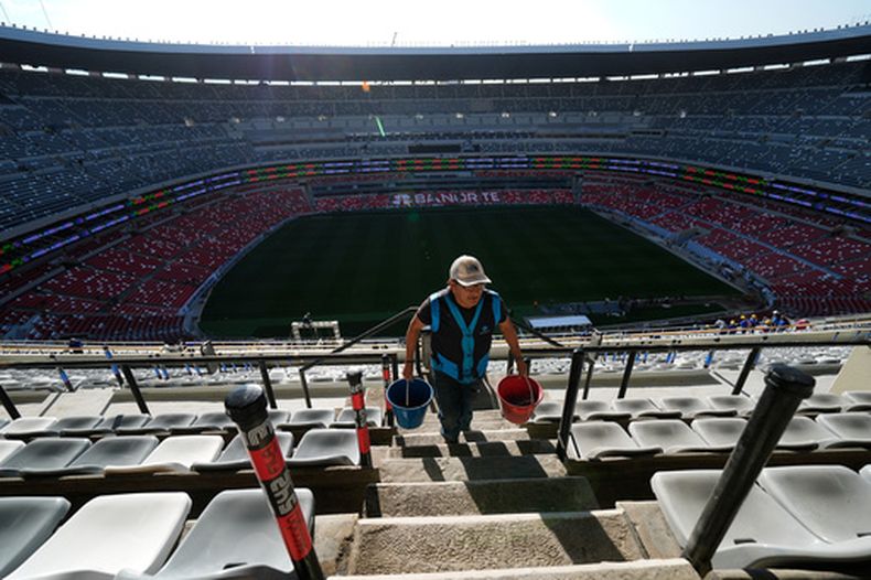 Un trabajador transporta baldes en el Estadio Azteca durante una visita de prensa para mostrar las renovaciones previas al Mundial de 2026, en la Ciudad de México, el jueves 26 de marzo de 2026. (Foto AP/Marco Ugarte)