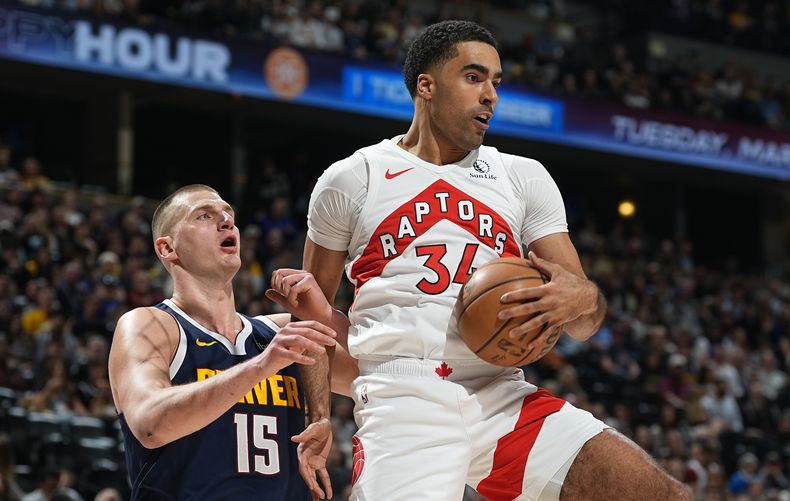 Jontay Porter, derecha, pívot de los Raptors de Toronto, descuelga un rebote frente a Nikola Jokic, de los Nuggets de Denver, en la primera mitad del juego de baloncesto de la NBA, el lunes 11 de marzo de 2024, en Denver. (AP Foto/David Zalubowski)