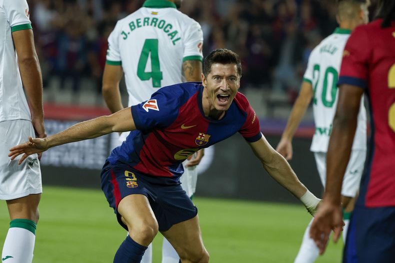 Robert Lewandowski (centro) celebra tras marcar un gol para el Barcelona en el partido contra Getafe en la Liga española, el miércoles 25 de septiembre de 2024, en Barcelona. (AP Foto/Joan Monfort)