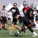 Kirk Cousins (8), quarterback de los Raiders de Las Vegas, entrega el balón al running back Ashton Jeanty (2) durante una práctica del equipo en el campaoento de entrenamiento, el jueves 30 de julio de 2026, en Henderson, Nevada. (AP Foto/Ian Maule)