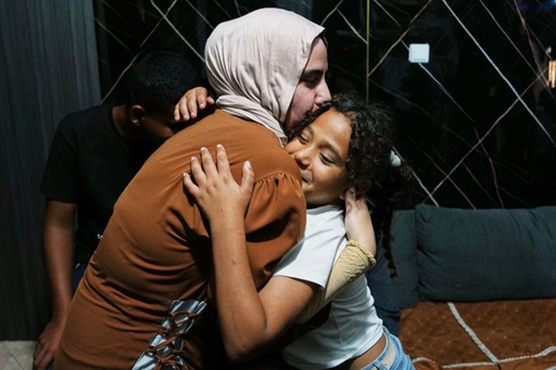 Mais Al-Gharam abraza a su hermana de 8 años Arjwan, quien recibió un pasaporte israelí, en su casa en Nazareth, Israel, el 8 de julio de 2026, tras la llegada de Arjwan desde la Franja de Gaza. (AP Foto/Mahmoud Illean)
