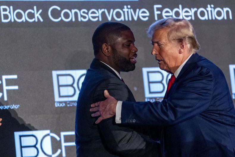 El expresidente Donald Trump saluda al representante republicano Byron Donalds, izquierda, tras hablar en la Gala Anual de Honores BCF de la Federación Conservadora Negra en el Centro de Convenciones Metropolitano de Columbia, el viernes 23 de febrero de 2024, en Columbia, Carolina del Sur. (AP Foto/Andrew Harnik)