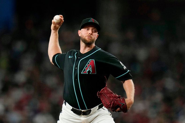 El lanzador abridor de los Diamondbacks de Arizona, Merrill Kelly, realiza un lanzamiento contra los Mets de Nueva York durante la primera entrada de un partido de béisbol, el sábado 9 de mayo de 2026, en Phoenix. (Foto AP/Ross D. Franklin)