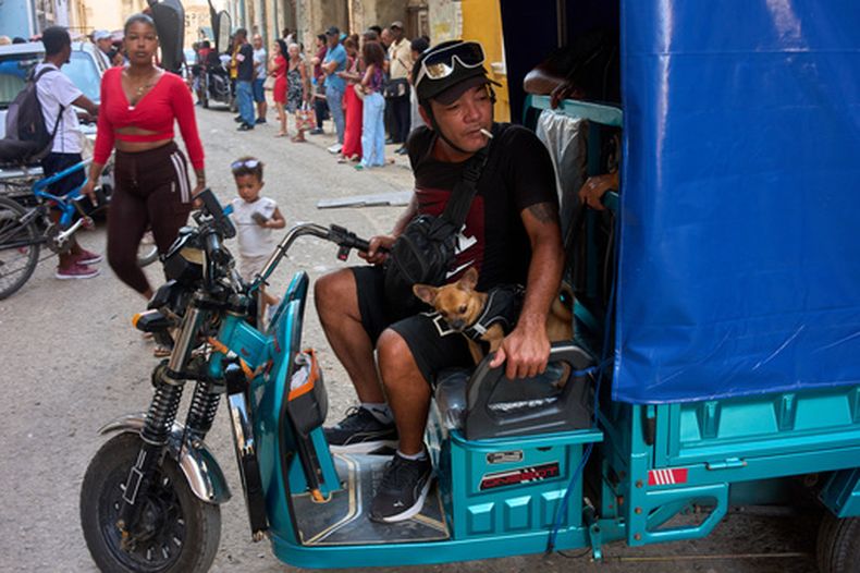 Un hombre maniobra su triciclo eléctrico junto a su perro pequeño en La Habana, Cuba, el miércoles 29 de julio de 2026. (Foto AP/Ramon Espinosa)