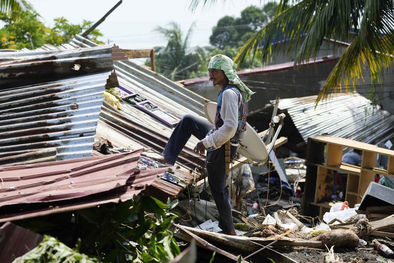 Vecinos intentan recuperar pertenencias de sus casas dañadas tras un reciente alud de tierra provocado por la tormenta tropical Trami en Talisay, provincia de Batangas, Filipinas, que dejó a miles de personas sin hogar y varios muertos el sábado 26 de octubre de 2024. (AP Foto/Aaron Favila)