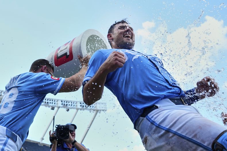 Luke Maile (derecha) de los Reales de Kansas City es bañado por Kyle Isbel tras el juego ante los Rangers de Texas, el jueves 21 de agosto de 2025, en Kansas City, Missouri. (AP Foto/Charlie Riedel)