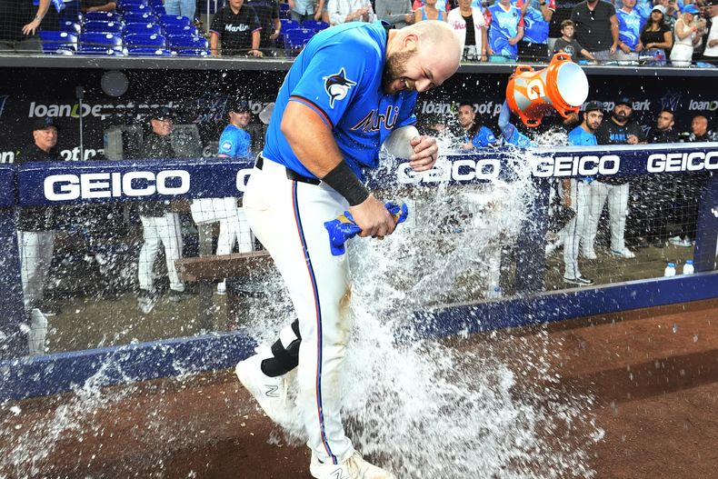 Jake Burger de los Marlins de Miami es mojado luego de impactar un jonrón para dejar tendido en el terreno a los Medias Blancas de Chicago, en el noveno episodio del juego de béisbol el domingo 7 de julio dde 2024, en Miami. (AP Foto/Lynne Sladky)